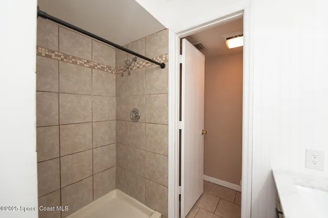 an empty room with a window and ceiling fan