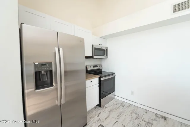 an empty room with a window and a ceiling fan