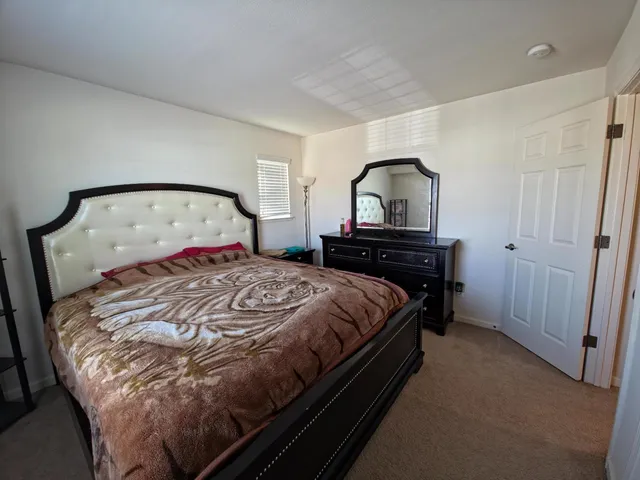 a bedroom with a bed and a mirror on dresser