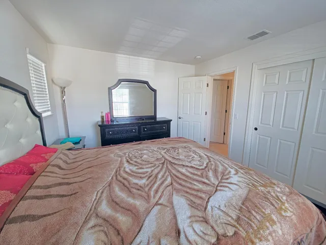 a bedroom with a bed and a mirror on dresser