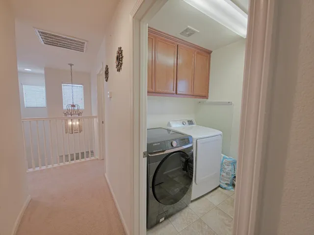 a utility room with cabinets washer and dryer