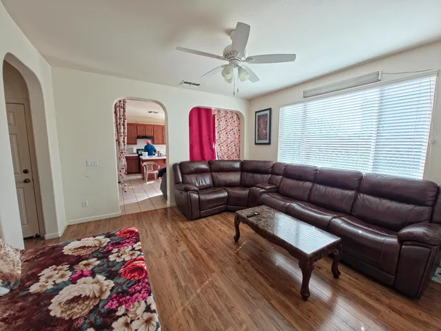 a living room with furniture ceiling fan and a window