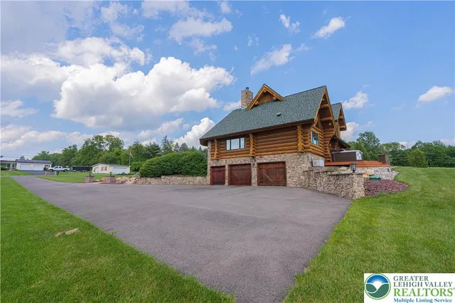 a view of a deck with wooden floor and roof with a floor to ceiling window next to a yard