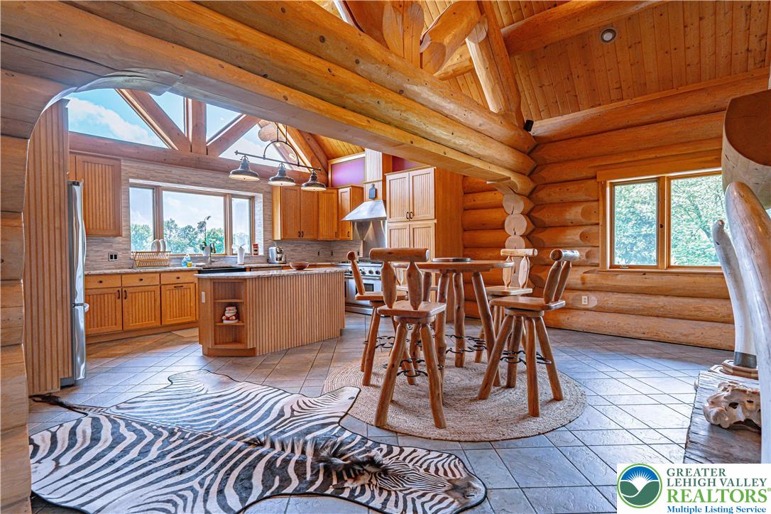 379 Meyer Road Nazareth, PA 18064 - Photo 30 of 78 a kitchen with stainless steel appliances kitchen island granite countertop a table chairs in it and wooden floors