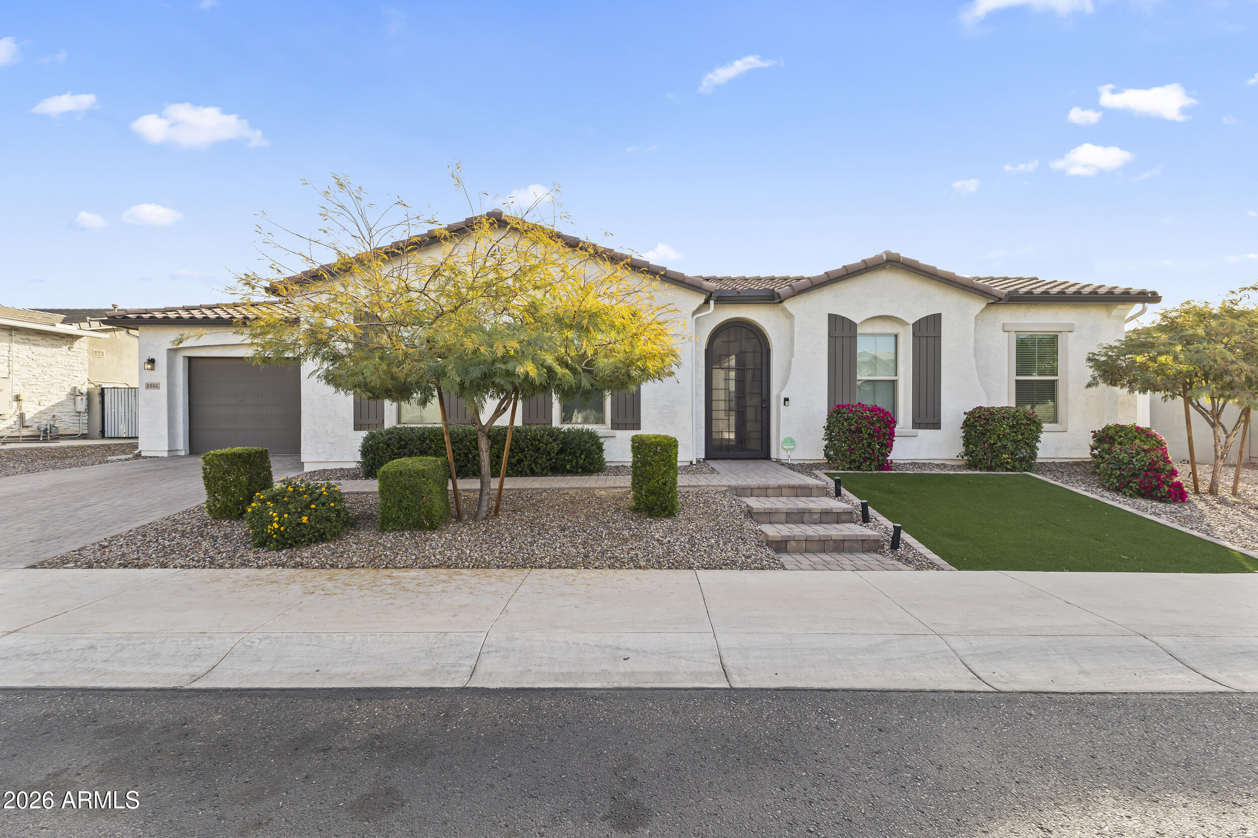 a view of a white house with a yard and plants