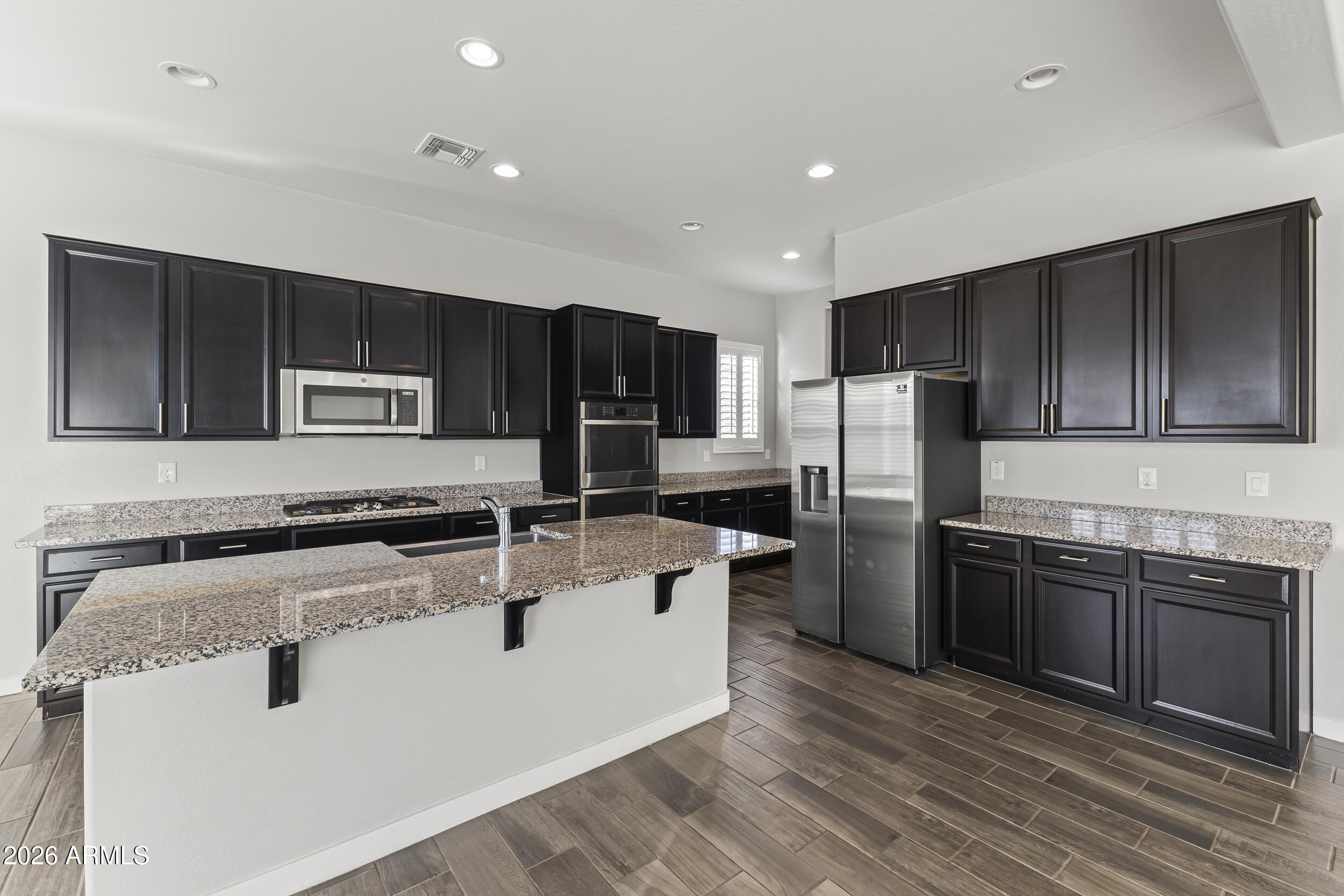 5255 North Ginning Road Litchfield Park, AZ 85340 - Photo 25 of 60 a kitchen with stainless steel appliances granite countertop a sink stove microwave and refrigerator