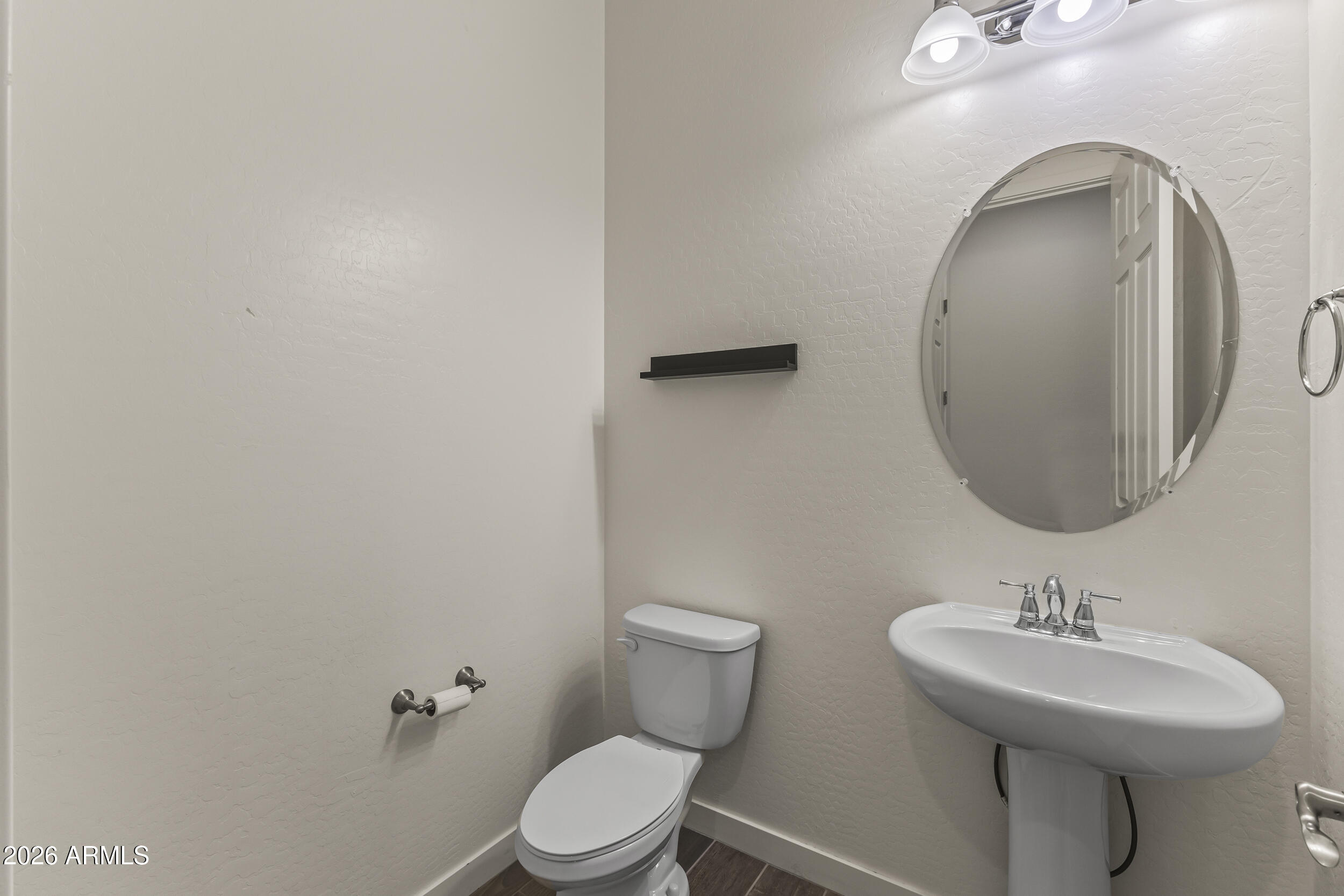 5255 North Ginning Road Litchfield Park, AZ 85340 - Photo 29 of 60 a bathroom with a toilet sink and mirror