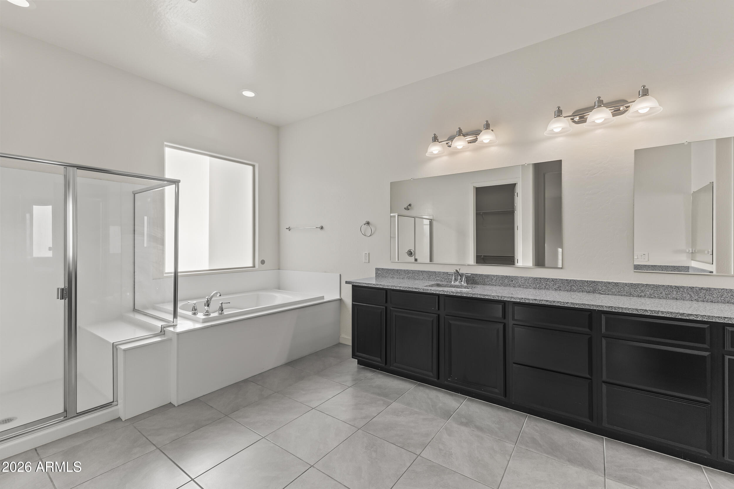 5255 North Ginning Road Litchfield Park, AZ 85340 - Photo 31 of 60 a spacious bathroom with a tub sink and mirror