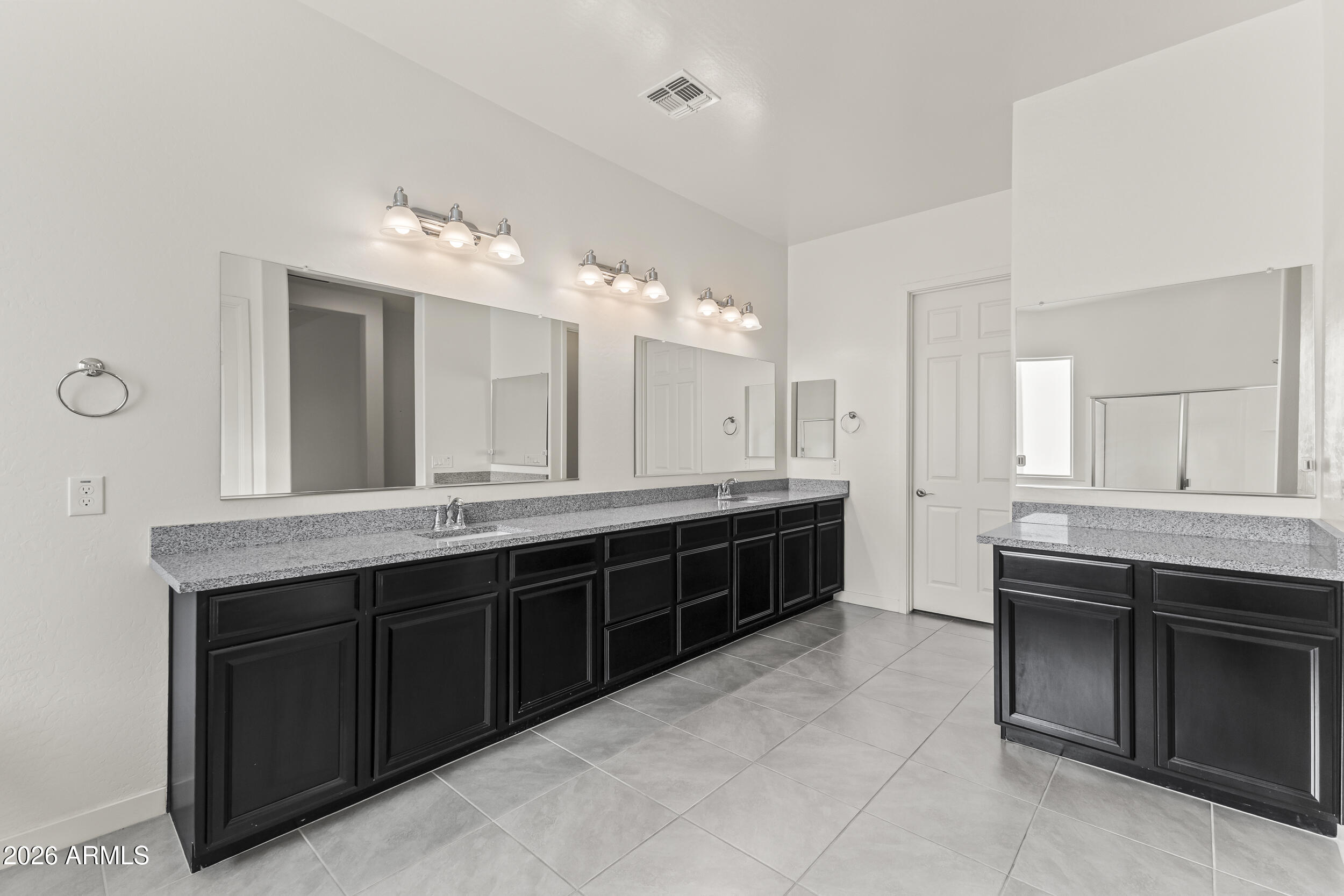 5255 North Ginning Road Litchfield Park, AZ 85340 - Photo 32 of 60 a spacious bathroom with a granite countertop double vanity sink a mirror and a bathtub