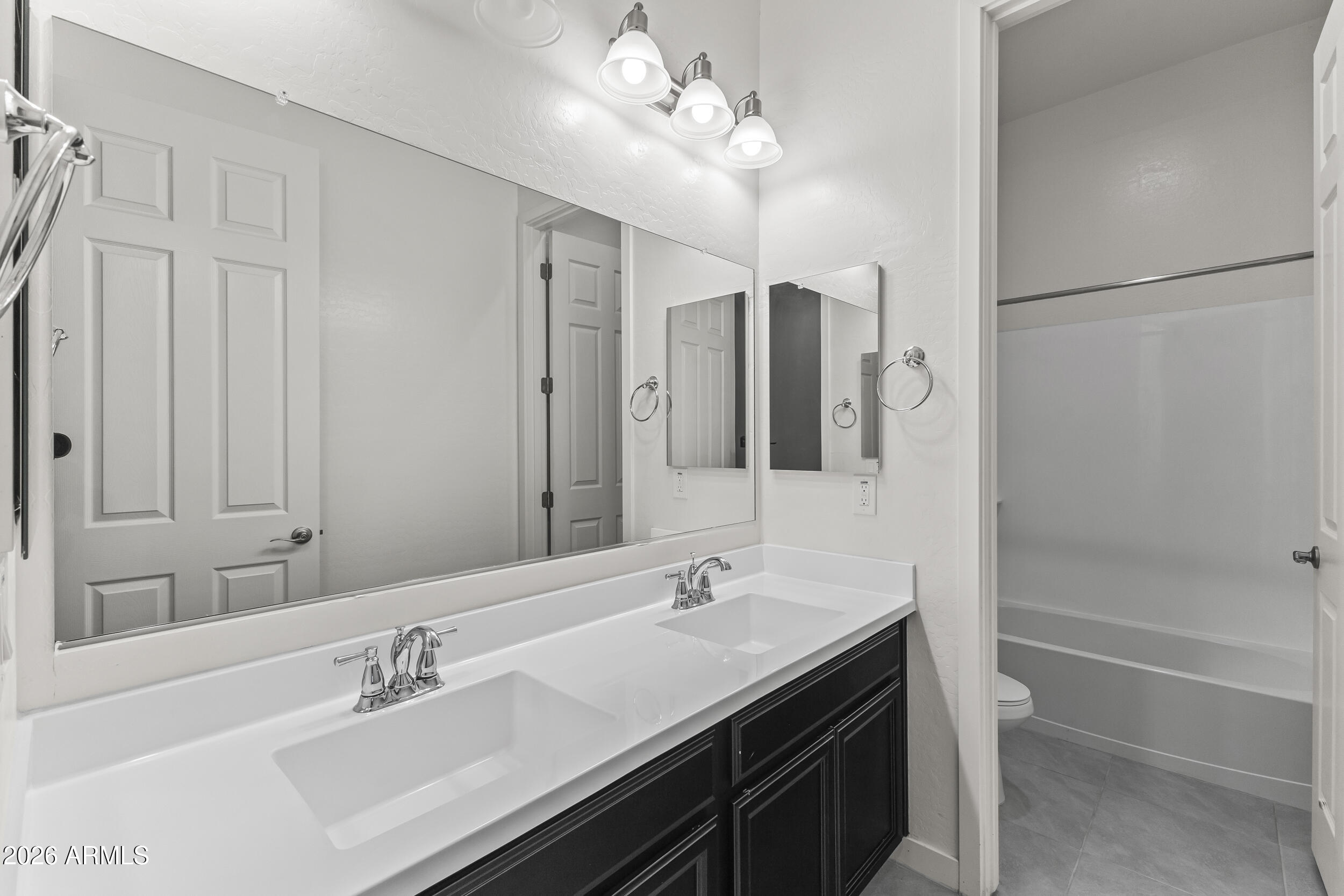 5255 North Ginning Road Litchfield Park, AZ 85340 - Photo 38 of 60 a bathroom with a double vanity sink a toilet and shower