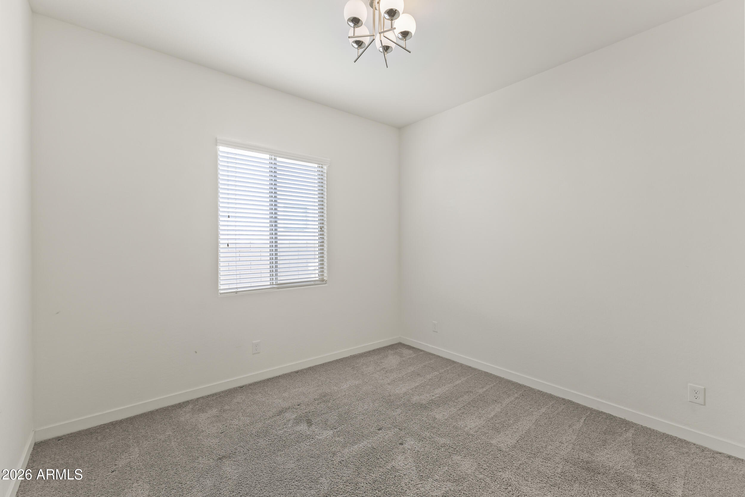 5255 North Ginning Road Litchfield Park, AZ 85340 - Photo 42 of 60 an empty room with a chandelier fan and window