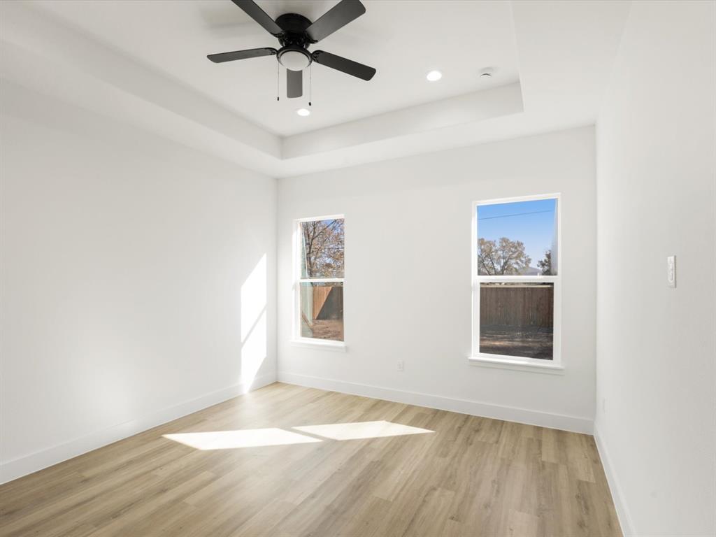 111 West Farmers Road Seagoville, TX 75159 - Photo 11 of 32 a view of an empty room with a window and wooden floor