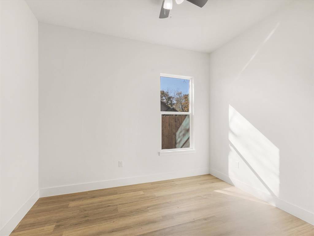 111 West Farmers Road Seagoville, TX 75159 - Photo 16 of 32 a view of an empty room with wooden floor and a window