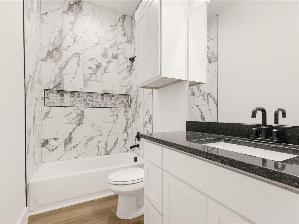 111 West Farmers Road Seagoville, TX 75159 - Photo 19 of 32 a bathroom with a granite countertop bathtub sink vanity mirror and toilet