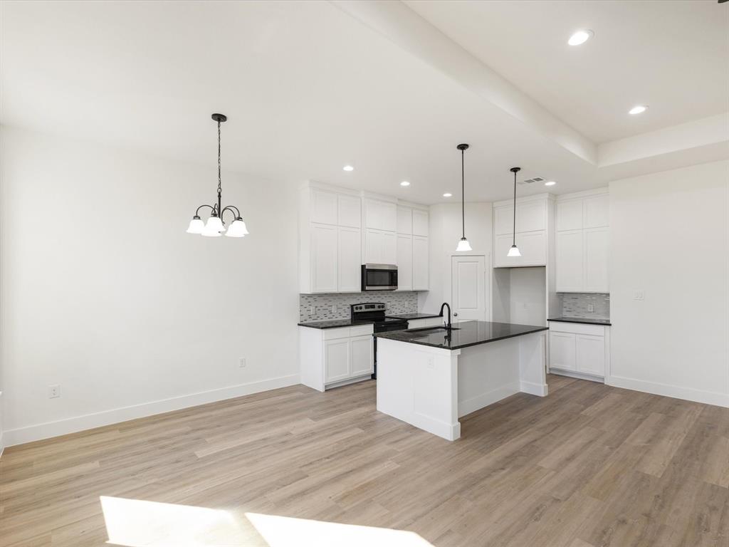 111 West Farmers Road Seagoville, TX 75159 - Photo 6 of 32 a kitchen with granite countertop a sink appliances and cabinets