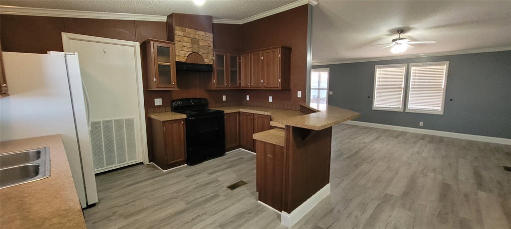 5543 Upper Denton Road Weatherford, TX 76085 - Photo 23 of 23 a kitchen with stainless steel appliances granite countertop a refrigerator a sink dishwasher a stove and a dining table with wooden floor