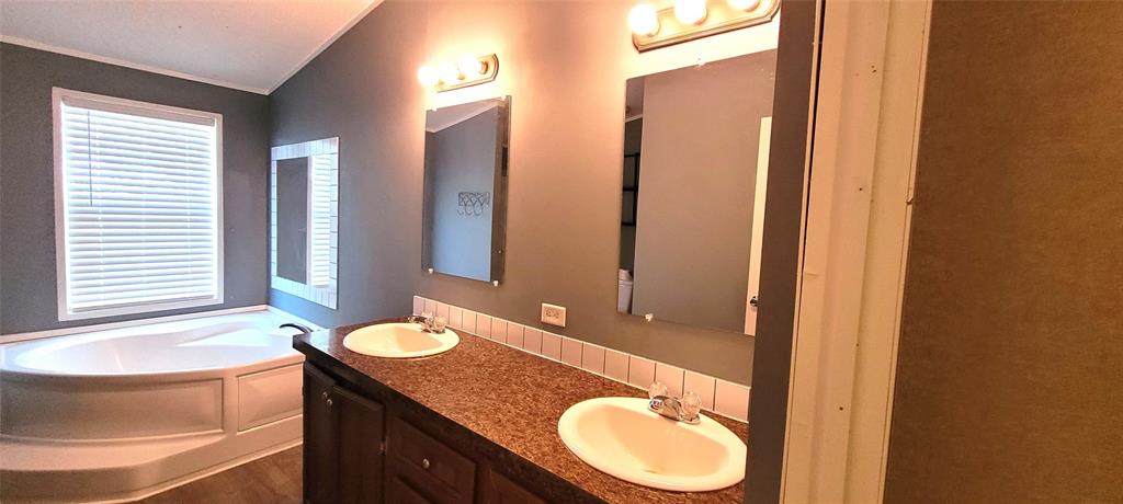 5543 Upper Denton Road Weatherford, TX 76085 - Photo 17 of 23 a bathroom with a granite countertop sink and a mirror