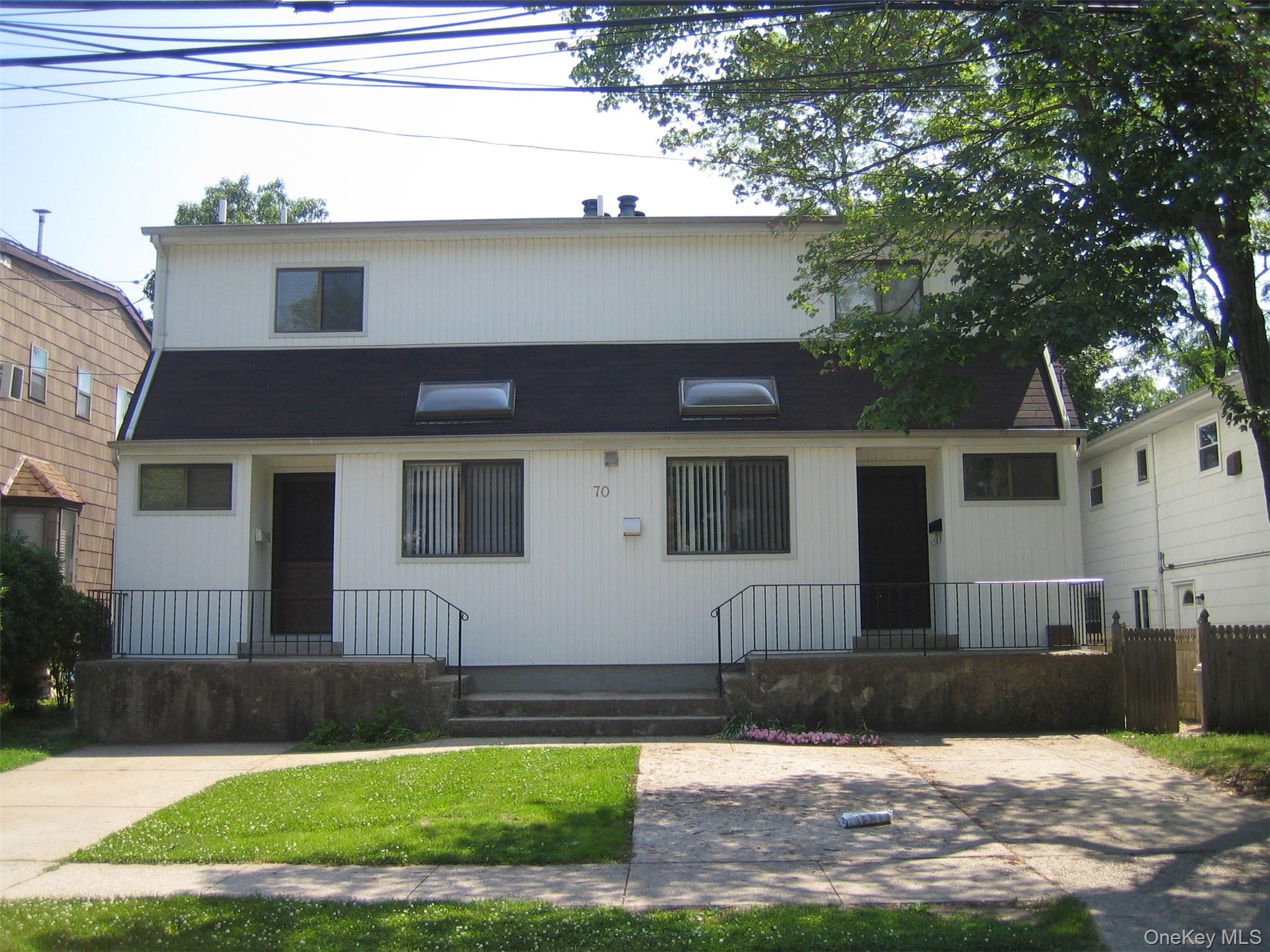 70 Hickory Road, Unit B Port Washington, NY 11050 - Photo 1 of 18 a front view of a house with a yard