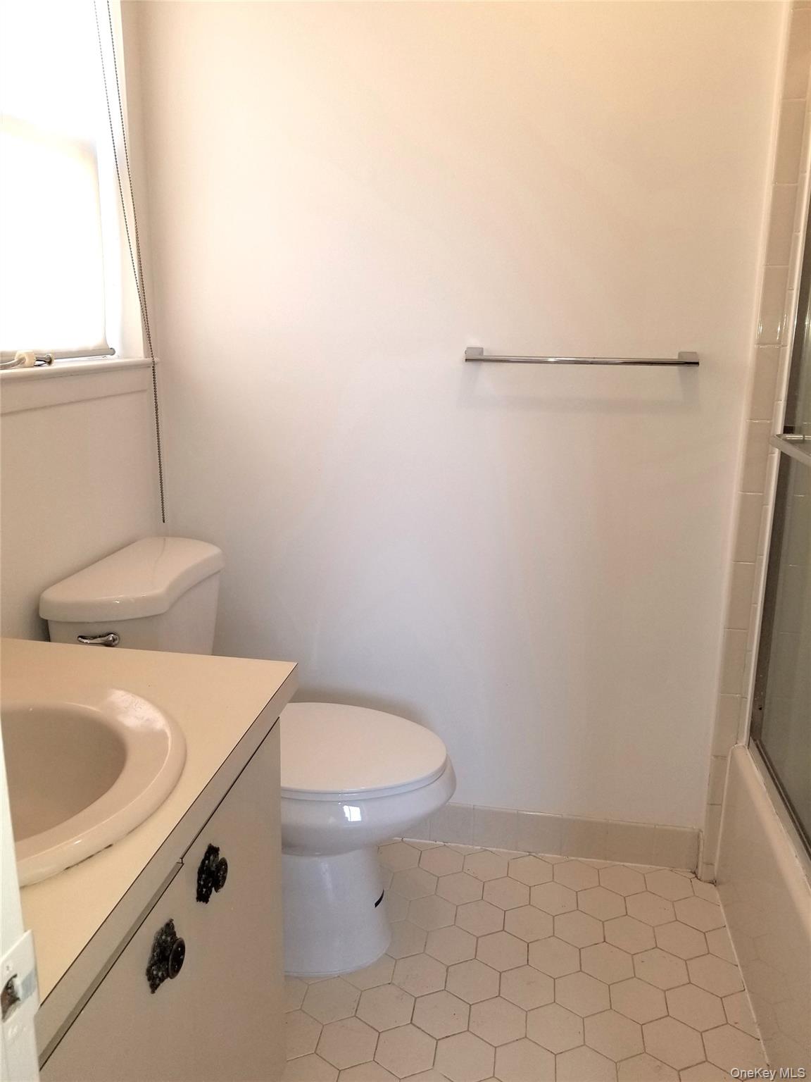 70 Hickory Road, Unit B Port Washington, NY 11050 - Photo 13 of 18 a bathroom with a sink a toilet and a window