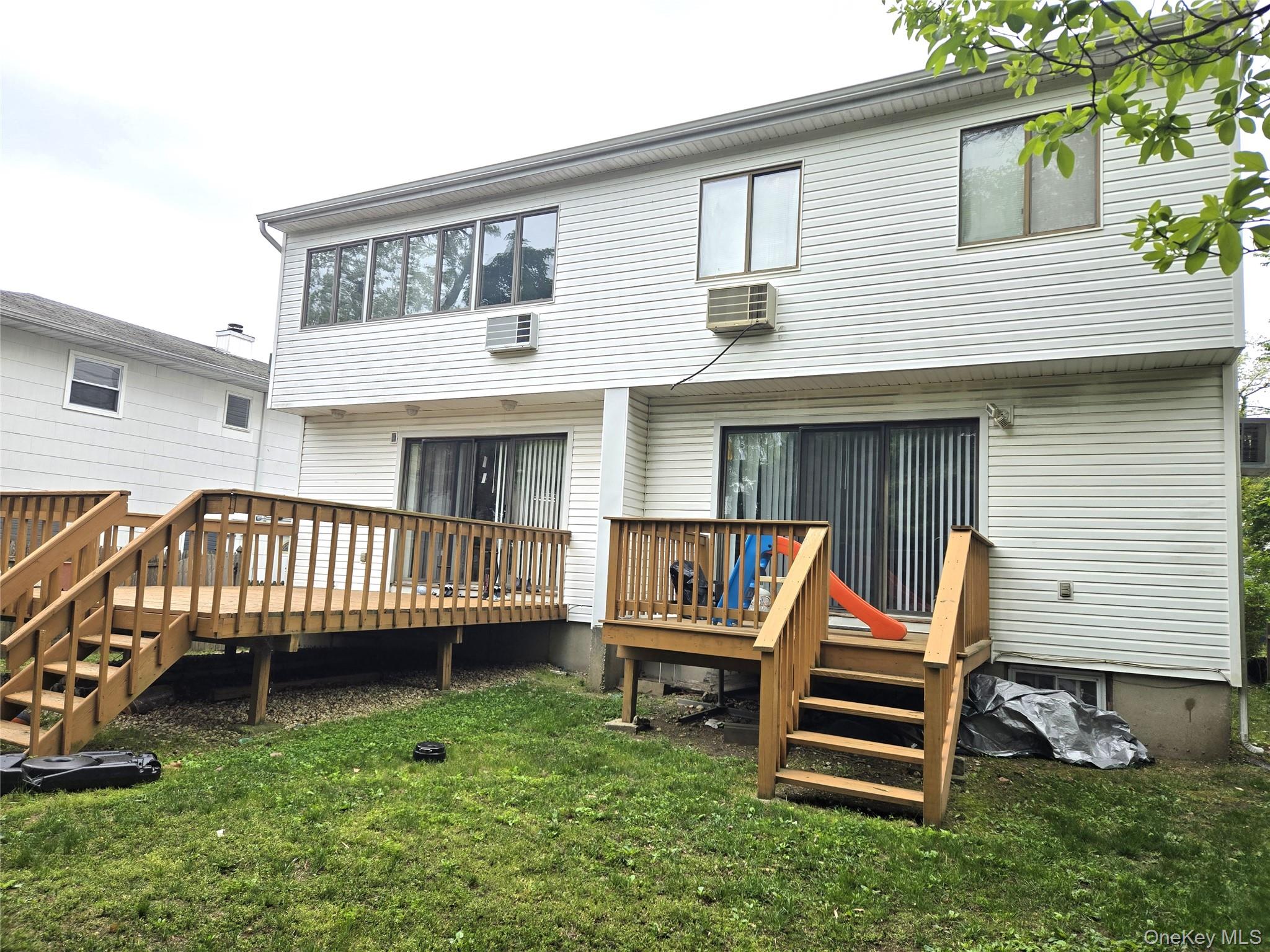 70 Hickory Road, Unit B Port Washington, NY 11050 - Photo 17 of 18 a view of a house with a deck and a yard