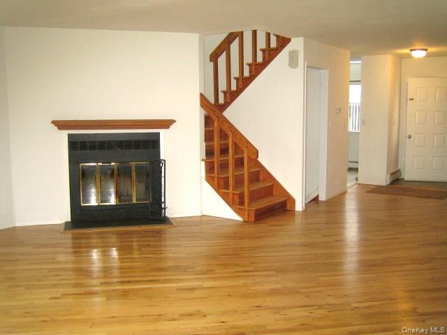 70 Hickory Road, Unit B Port Washington, NY 11050 - Photo 3 of 18 a view of empty room with wooden floor and fan
