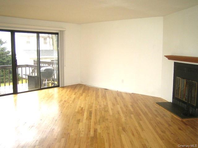 70 Hickory Road, Unit B Port Washington, NY 11050 - Photo 4 of 18 a view of empty room with wooden floor and fan