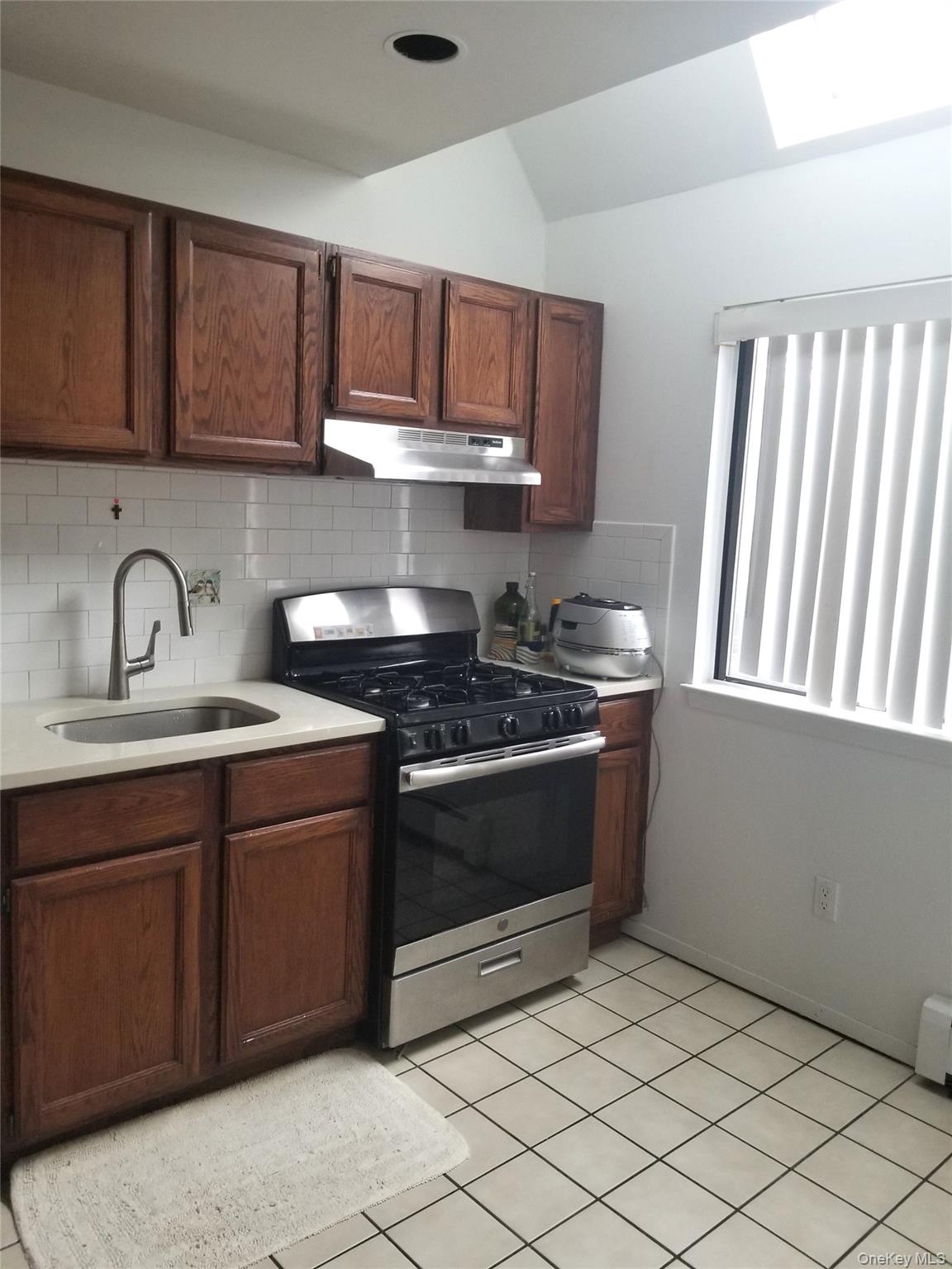 70 Hickory Road, Unit B Port Washington, NY 11050 - Photo 6 of 18 a kitchen with stainless steel appliances granite countertop a stove a sink and a microwave