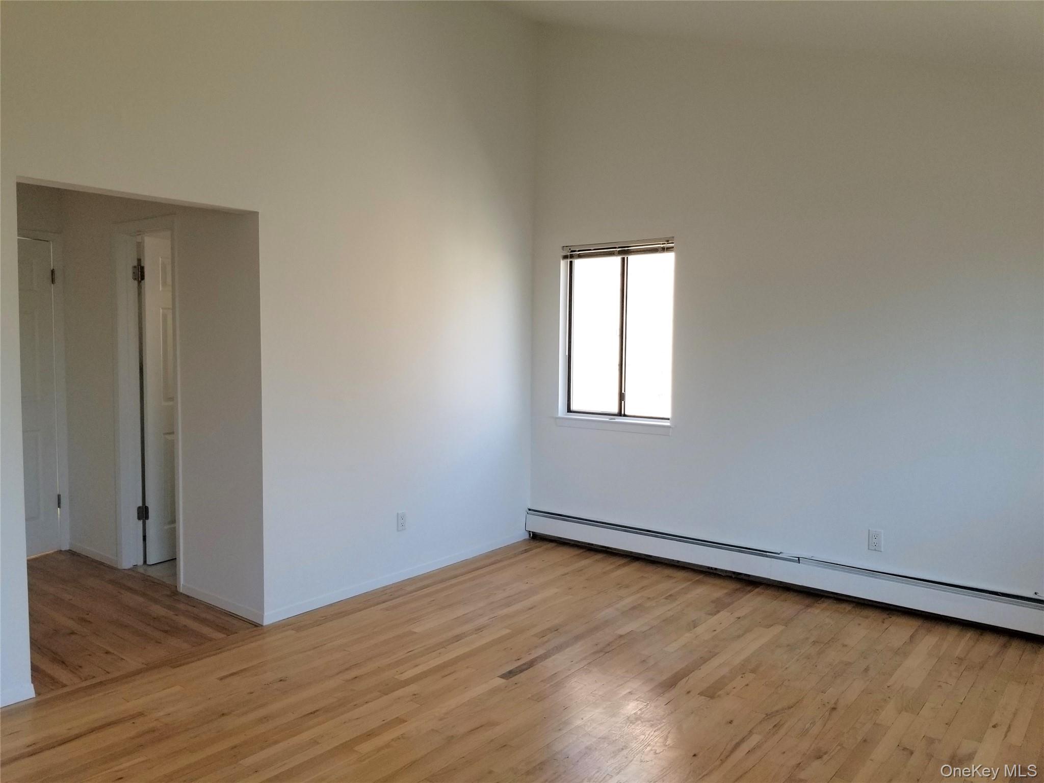 70 Hickory Road, Unit B Port Washington, NY 11050 - Photo 8 of 18 an empty room with wooden floor and windows