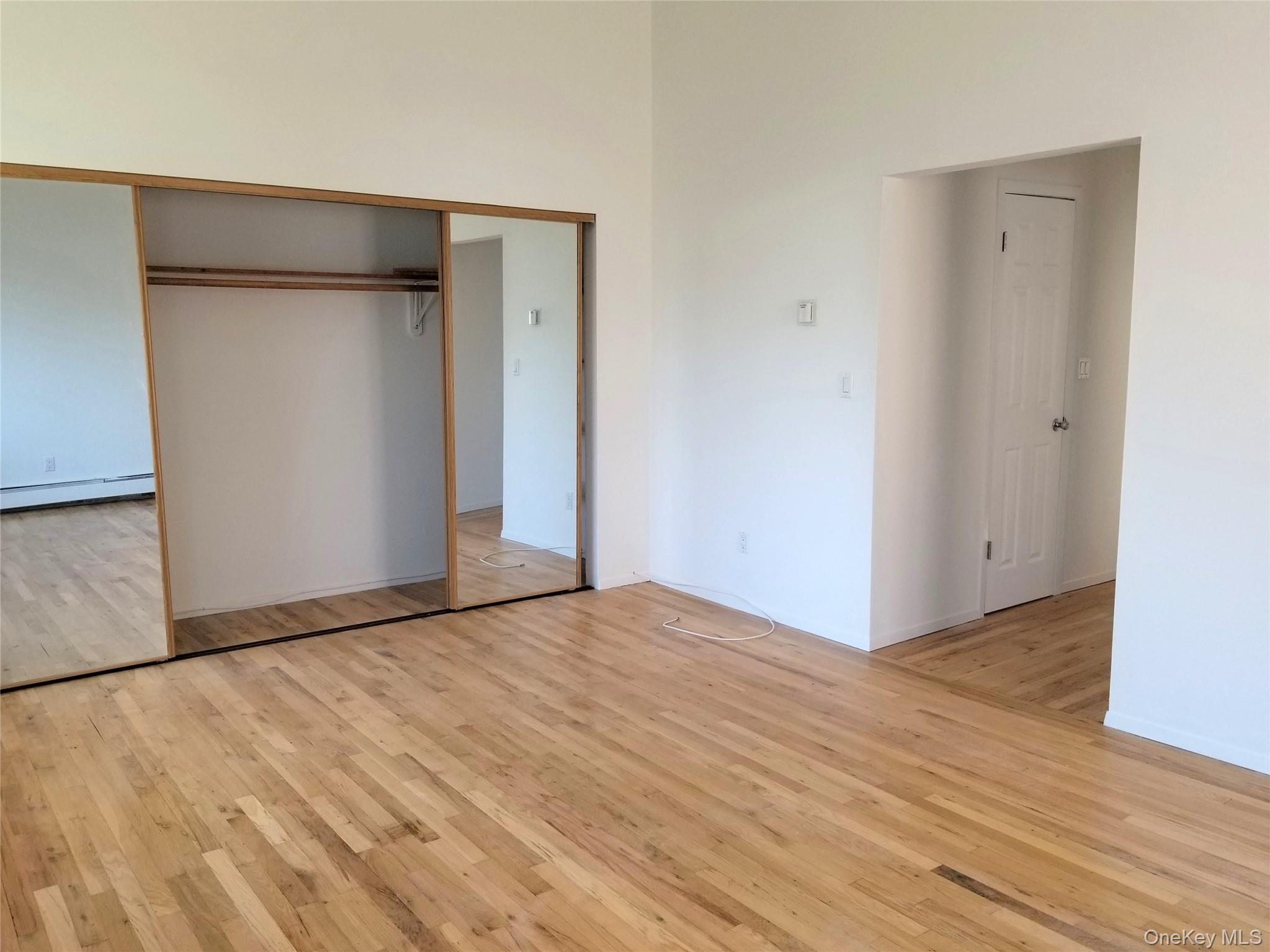 70 Hickory Road, Unit B Port Washington, NY 11050 - Photo 9 of 18 a view of an empty room with wooden floor