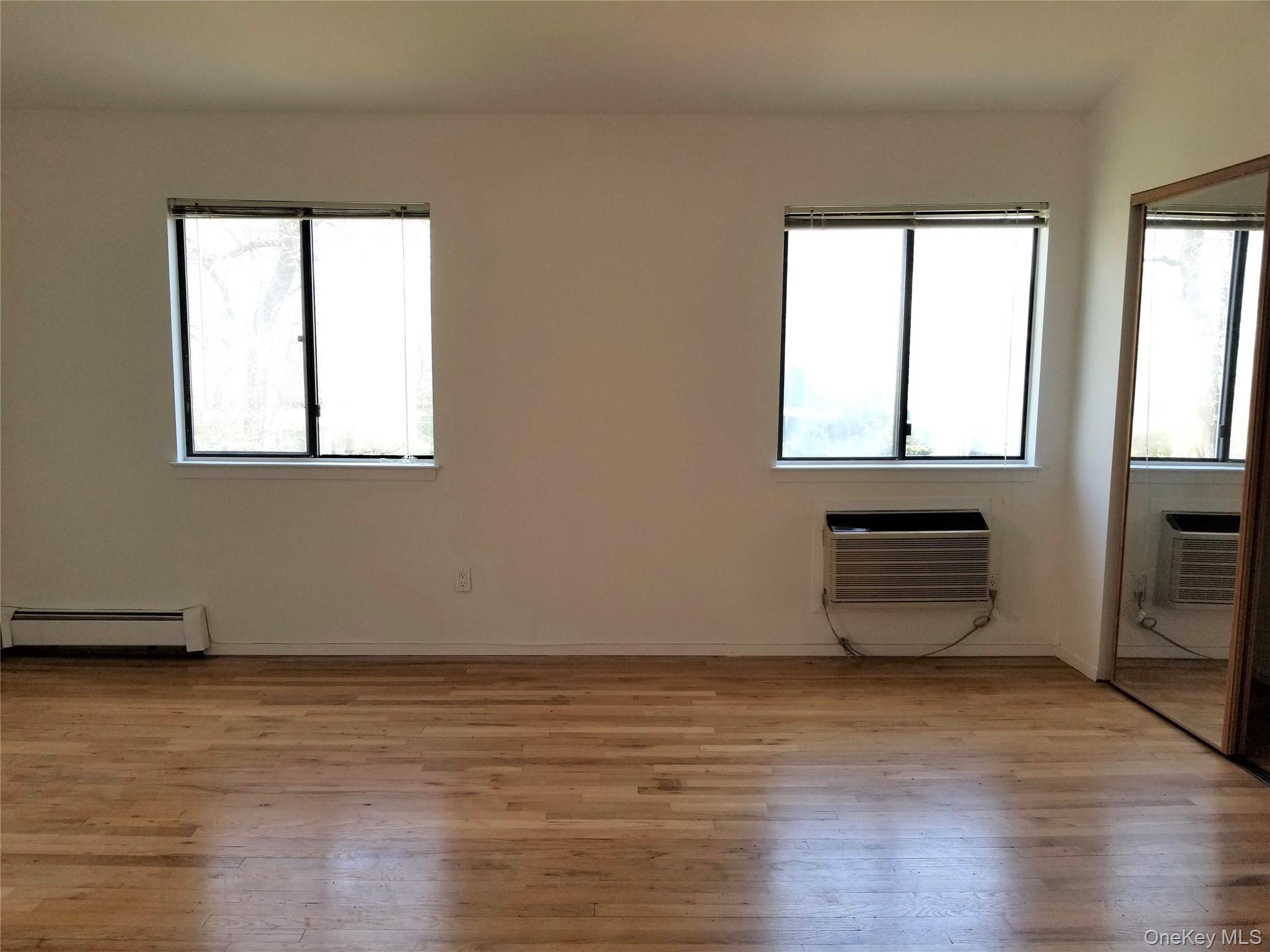70 Hickory Road, Unit B Port Washington, NY 11050 - Photo 10 of 18 a view of an empty room with wooden floor and a window