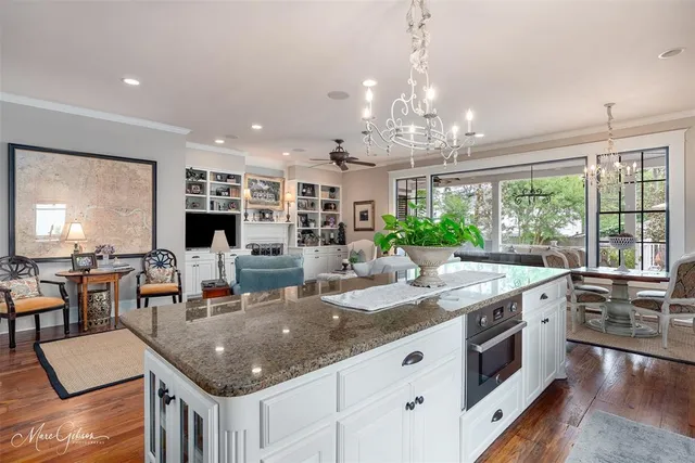 a kitchen with granite countertop a stove and white cabinets