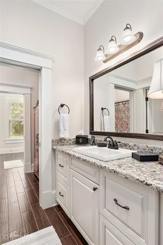 a bathroom with a granite countertop double vanity sink and mirror