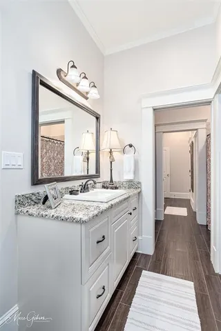 a bathroom with a granite countertop sink mirror and window