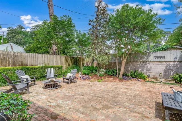 a view of backyard with outdoor seating and trees