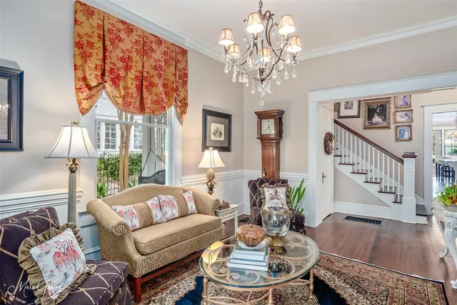 a living room with furniture a chandelier and a table