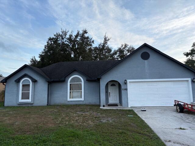 1142 Southwest Bayamo Avenue Port St. Lucie, FL 34953 - Photo 2 of 19 a front view of a house with garden