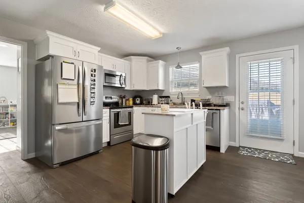 a kitchen with white cabinets and stainless steel appliances