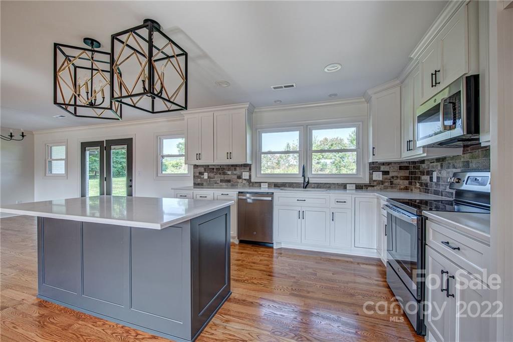 649 Loray Farm Road Dallas, NC 28034 - Photo 17 of 44 a kitchen with stainless steel appliances granite countertop a stove and cabinets