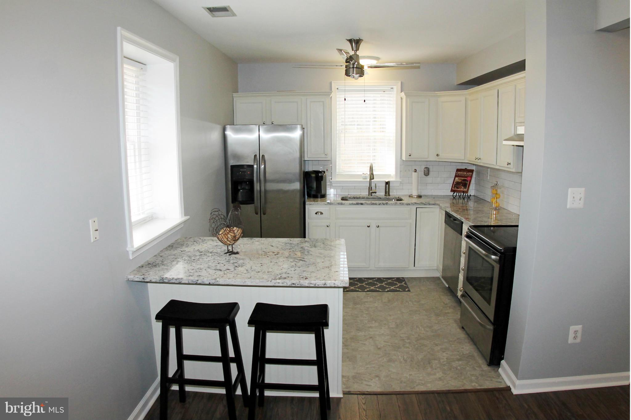 26722 Ridge Road Damascus, MD 20872 - Photo 13 of 30 a kitchen with stainless steel appliances granite countertop a kitchen island hardwood floor sink and stove