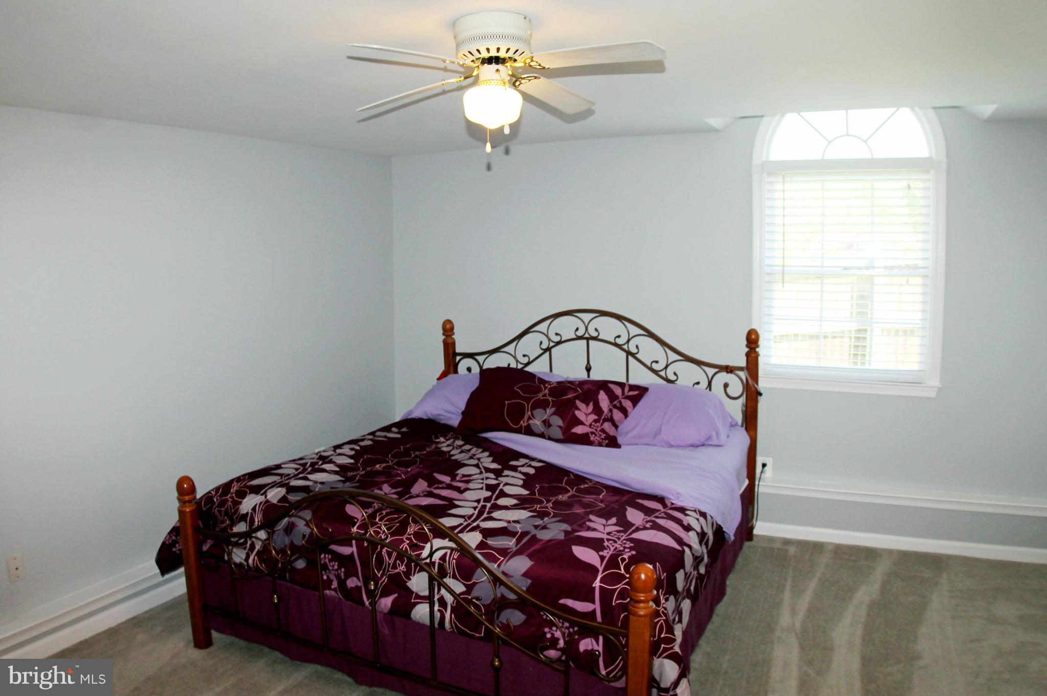 26722 Ridge Road Damascus, MD 20872 - Photo 14 of 30 a bedroom with a bed and a chandelier