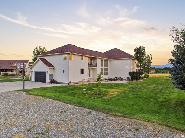 702 Alpine Highway Alpine, UT 84004 - Photo 79 of 83 Spacious two-story residence featuring a gravel driveway, attached garage, large rear patio, and expansive green lawn