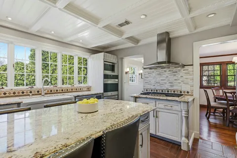 a kitchen with a stove and chairs
