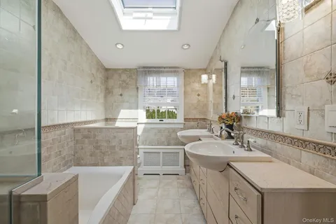 a bathroom with a tub sink and mirror