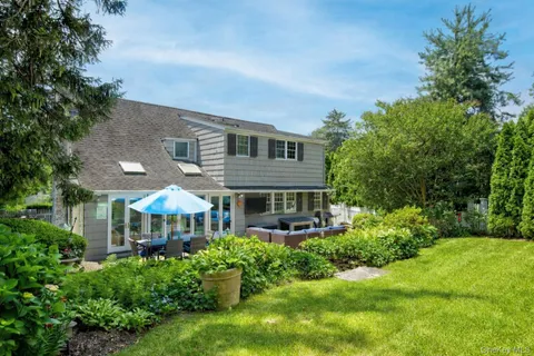 a front view of a house with a yard and potted plants