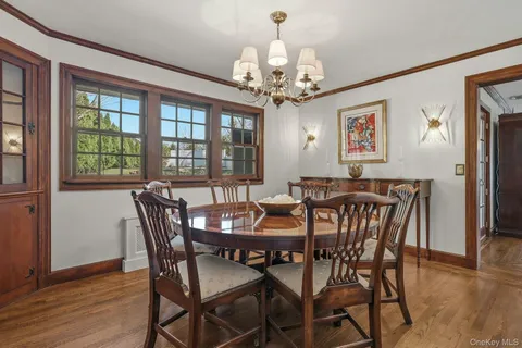 a view of a dining room with furniture a chandelier and wooden floor