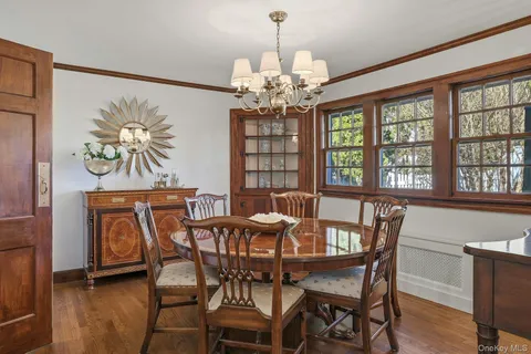 a view of a dining room with furniture a chandelier and wooden floor