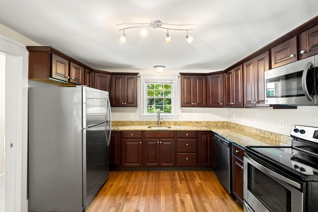 12 Chestnut Street Danvers, MA 01923 - Photo 32 of 37 a kitchen with stainless steel appliances granite countertop wooden cabinets a stove top oven a sink and dishwasher