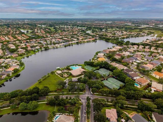 an aerial view of ocean and residential houses with outdoor space