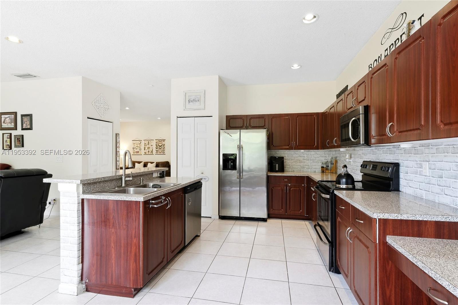 15025 Southwest 19th Court Miramar, FL 33027 - Photo 3 of 27 a large kitchen with stainless steel appliances granite countertop a stove top oven a refrigerator a sink and dishwasher