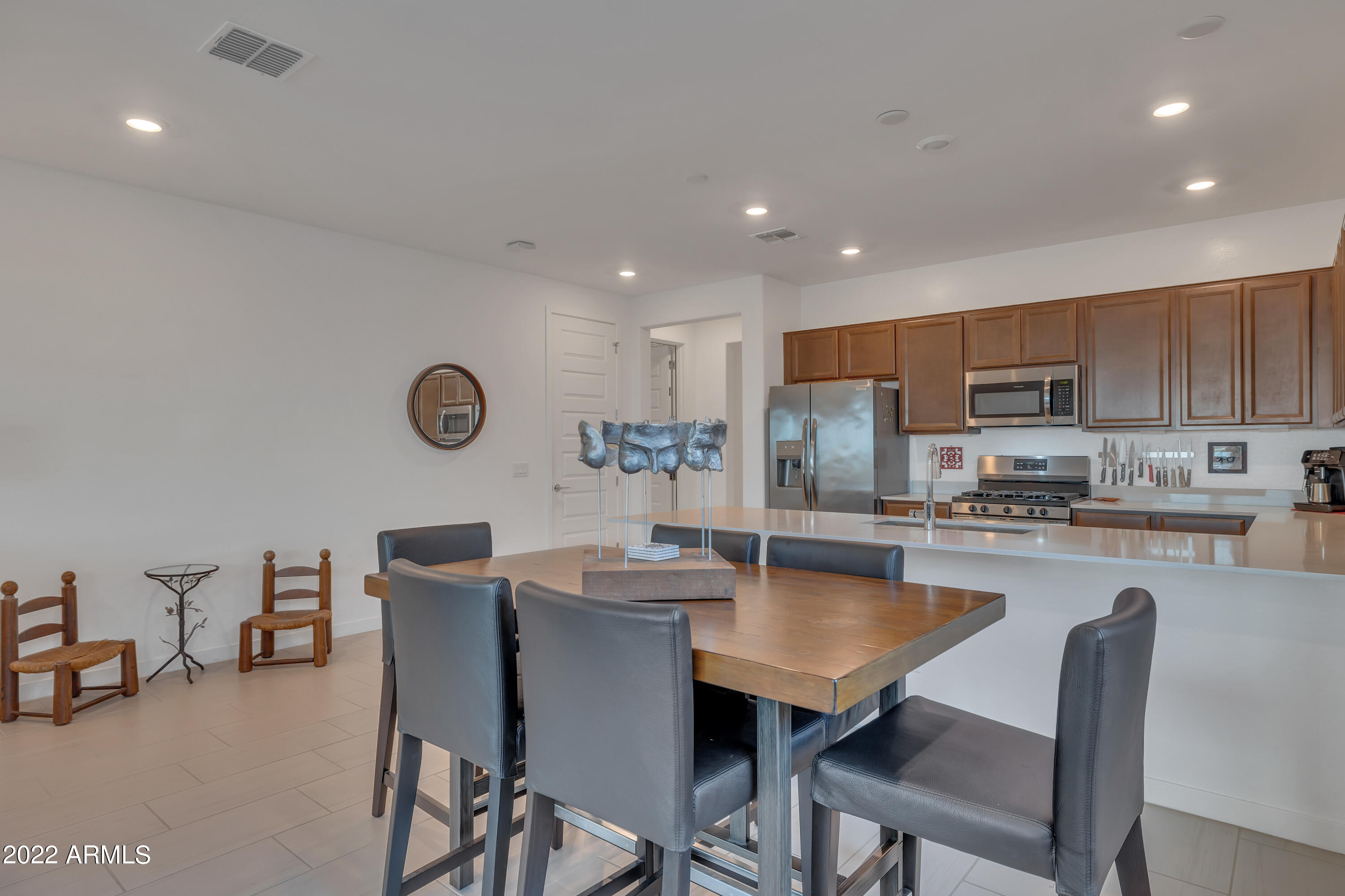 9630 West Atlantis Way Tolleson, AZ 85353 - Photo 11 of 37 a kitchen with a dining table chairs and microwave